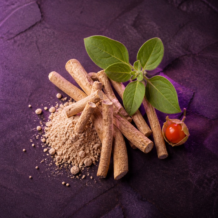 Dried ashwagandha root pieces with powder, leaves and a winter cherry berry